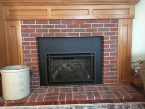 metal fireplace surrounded by brick